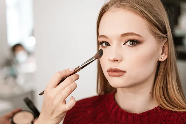 Woman applying clean makeup in natural light