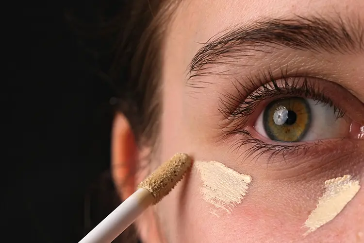 Applying concealer under eye — mature skin blending