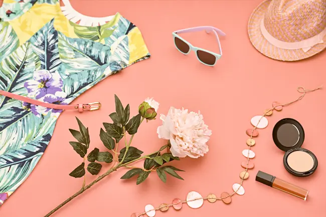 Summer makeup products flatlay — primers, setting spray and lightweight foundation for hot weather